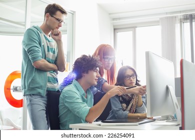 Creative Business Colleagues Discussing Over Computer In Office