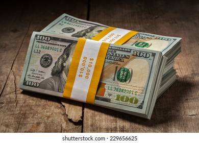 Creative Business Finance Making Money Concept - Stacks Of New 100 US Dollars 2013 Edition Banknotes (bills) Bundles Isolated On Wooden Background