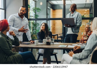 Creative business professionals having a group discussion during a meeting in a modern office. Team of multicultural businesspeople sharing ideas in an inclusive workplace. - Powered by Shutterstock