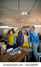 Creative Business Team Giving A High Five To Each Other In Office