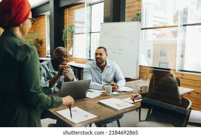 Creative Business Team Sharing Ideas During A Boardroom Meeting. Group Of Multicultural Business Professionals Having A Discussion In An Inclusive Workplace.