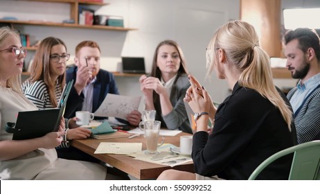 Creative Business Team At Table In A Modern Startup Office. Female Speaker Offers A Great Idea And The Team Supports Her