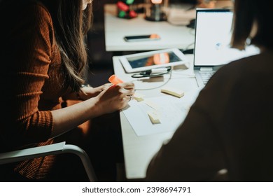 Creative business team working together on a late-night project deadline, analyzing reports and discussing strategies for business growth in a collaborative and innovative office environment. - Powered by Shutterstock