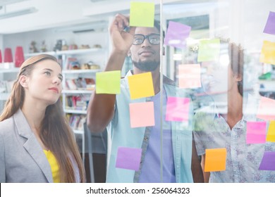 Creative Business Team Writing On Adhesive Notes In Office