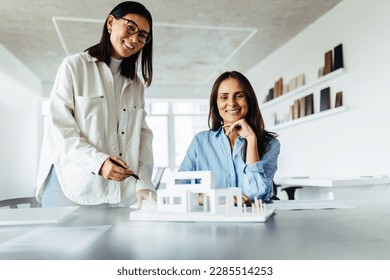 Creative business women working with a 3D model in an office. Female architects collaborating on a new house design project. - Powered by Shutterstock