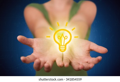 A creative businessman has a great bright idea illustrated by holding a drawn light bulb in the hand concept - Shutterstock ID 341854559