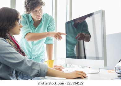 Creative Businessman Showing Something To Colleague On Desktop Computer In Office