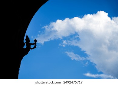 Creative capture of statue that look like shooting the cloud from its mace