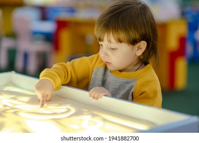 Creative child development. Baby draws sand on glass. Early development of children. Development of shallow motility and tactile sensations. - Powered by Shutterstock