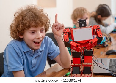 Creative Child Making A Robot, Reaching An Amazing Result. Boy Has An Aha Moment, Euereka, And Surprised Face On A Display.