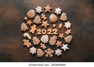 Creative Christmas composition as ball of assorted cookies with date 2022 inside on a brown background. New Year greeting card. Top view. Xmas festive holiday.