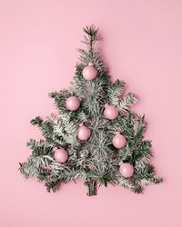 Creative Christmas Layout Made With Pine Tree Fir And Shiny Bauble Ornaments On Pink Pastel Background. Minimal Winter Or New Year Seasonal Concept. Flat Lay, Top View.