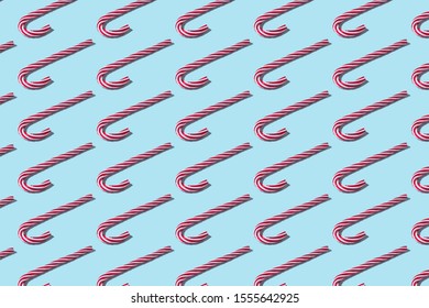Creative Christmas pattern made of Christmas candy on bright blue background. Minimal Christmas or New Year concept.