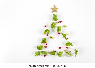 Creative Christmas tree shape made with melting ice on white background. Minimal holiday concept. Flat lay. Copy space.