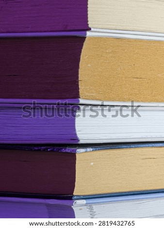 Creative close up of book pages split into deep purple and warm golden tones.