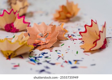 Creative close-up of colorful pencil shavings on a white background, symbolizing art, creativity, and inspiration - Powered by Shutterstock