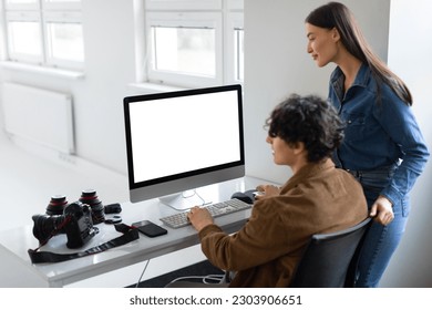 Creative collaboration concept. Male photographer and his female assistant checking and discussing photos, using computer, working in team in photostudio, mockup