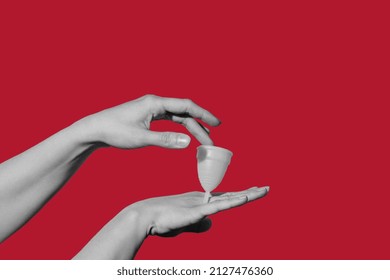 Creative Collage Of Hands With A Menstrual Cup On A Red Background. Menstruation, Women's Health Concept. Added The Effect Of Noise On The Hands As A Trend In The Photo.