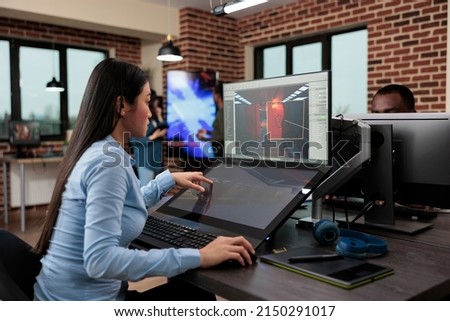 Creative company game developer sitting in production department while developing 3D videogames scenes and environment. Asian employee working on level design using modern software.
