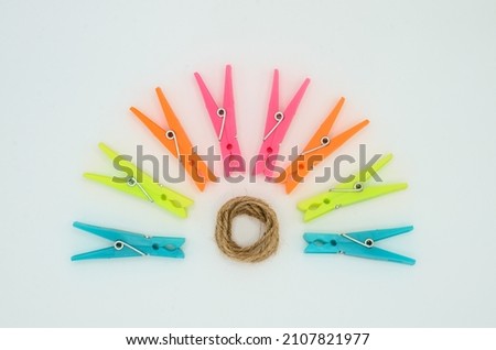 creative composition colorful semicircle sun plastic clothes pin rolled up rope