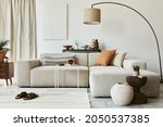 Creative composition of cozy living room interior design with mock up poster frame and structure painting, corner sofa, coffee table, textile and personal accessories. Scandinavian classic style.