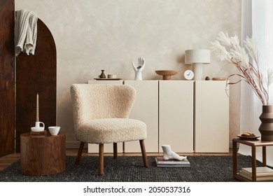 Creative composition of cozy living room interior design with mock up poster frame, fluffy armchair, folding screen, coffee table, commode and personal accessories. Modern style. Template.