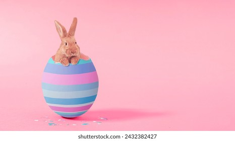 Creative composition with cute Easter bunny rabbit which peeking from broken colorful Easter Egg on pink background. Creative art,minimal aesthetic look.Contemporary style.Minimal easter concept - Powered by Shutterstock