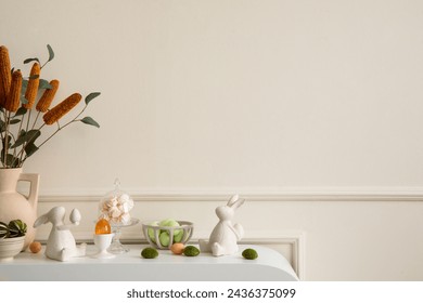 Creative composition of easter living room interior with copy space, beige vase with dried flowers, glass eggs, easter bunny sculpture and personal accessories. Home decor. Template.