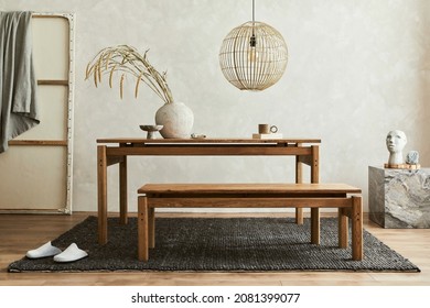 Creative composition of elegant dining room interior design with wooden family table, bench and beautiful home decorations and accessories. Modern home concept. Wabi-sabi inspiration. Template.