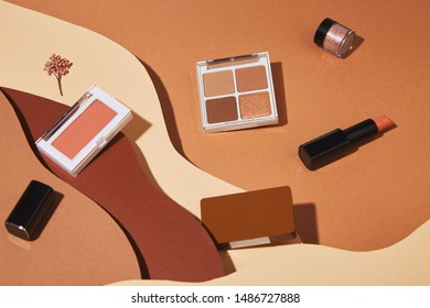 Creative composition falling makeup cosmetics. Brown, beige colors, top view