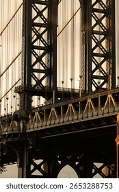 A creative composition featuring the Empire State Building perfectly framed through the arch of the Manhattan Bridge, capturing iconic New York architecture at sunset.