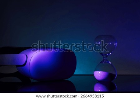 Creative composition featuring a glowing VR headset paired with an hourglass, symbolizing technology and time, on a textured blue backdrop. Perfect for tech, innovation, and timeless concept themes.