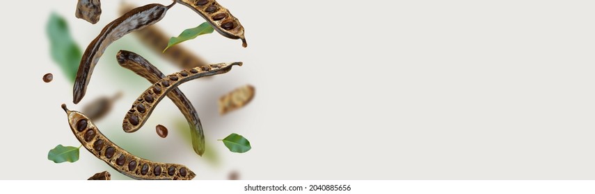 Creative composition. Floating Organic carob pods, seeds, leafs. food background. Natural vegan eating. Flying Organic product. Levitation concept, falling healthy sweets. horizontal banner.Copy space