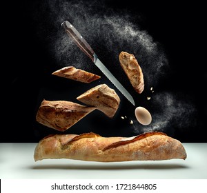 Creative Composition Of Flying Bread, Egg, Flour, Crumbs And A Knife