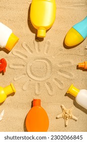 Creative composition with frame made of different sunscreen creams on sand