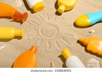 Creative composition with frame made of different sunscreen creams on sand