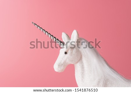 Creative composition with glitter unicorn on pink background. Minimal holiday concept.