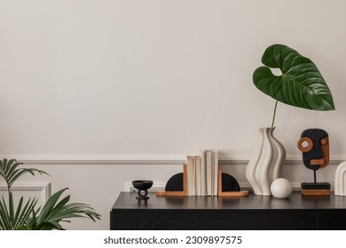 Creative composition of living room interior with copy space, black desk, stylish vase with green leaves, wall with stucco, wooden sculpture, plants and personal accessories. Home decor. Template. - Shutterstock ID 2309897575