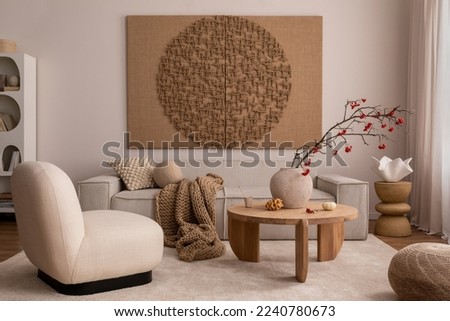 Creative composition of living room interior with mock up poster frame, beige sofa, wooden coffee table, rounded shapes armchair, vase with rowanberry and personal accessories. Home decor. Template.