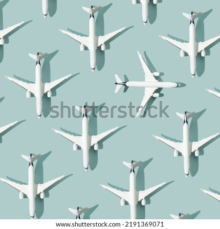 Creative composition made with white passenger plane on pastel blue background. Summer travel or vacation pattern. Flat lay, square composition