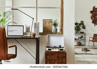 Creative composition of modern masculine home office workspace interior with black industrial desk, brown leather armchair, laptop, vintage record player and stylish personal accessories. Template. - Powered by Shutterstock