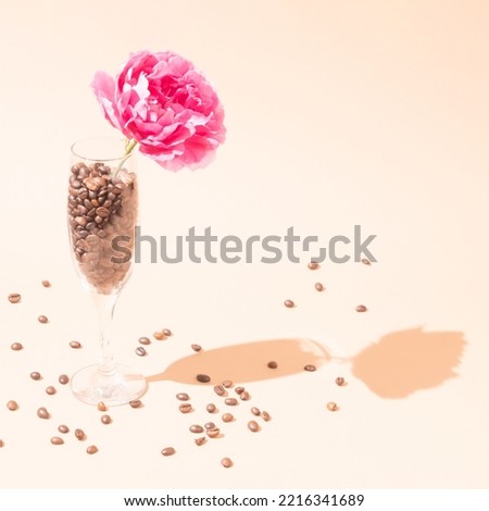 Creative composition of pastel colors. Coffee beans in a wine glass, with rose.