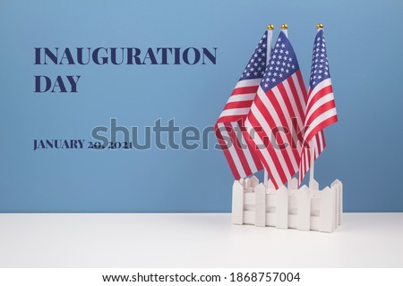 Creative composition with USA flags on white table with blue wall background, copyspace for text. Inauguration Day 2021 concept