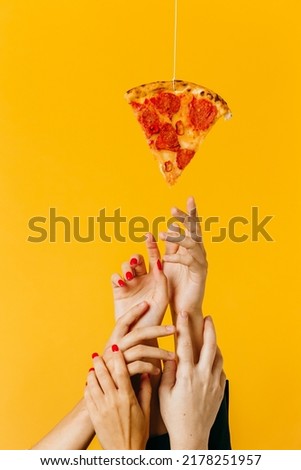 Creative concept advertising fast food. Hands reach for a piece of pizza.