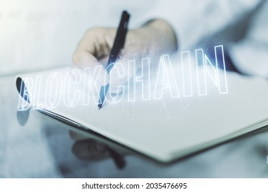 Creative concept of blockchain technology and man hand writing in notebook on background. digital money transfers and decentralization concept. Multiexposure