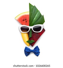 Creative concept of cubist style female face in sunglasses made of fruits and vegetables, on white background.