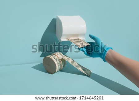 Creative concept of the economic crisis of 2020, monetary inflation during the coronavirus. The photo shows dollars, toilet paper and protective gloves.