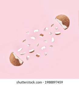 Creative Concept Of The Fresh, Organic Coconut Cut In Half With Small Pieces. 
Healthy Fruit Explosion On Pastel  Pink Background.