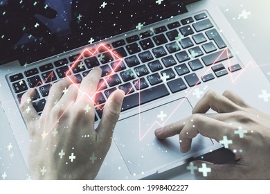 Creative concept of heart pulse illustration and hands typing on laptop on background. Medicine and healthcare concept. Multiexposure