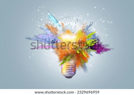 Creative concept light bulb explodes with colorful water colors on a light blue background. Think different, creative idea. Productivity and creativity